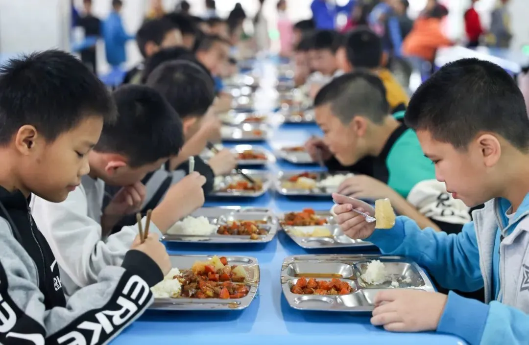 2021年10月19日，四川省华蓥市高兴镇小学的学生在食堂领取“安全放心餐”。